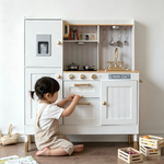 Child playing with the play kitchen fridge and pretend ice dispenser